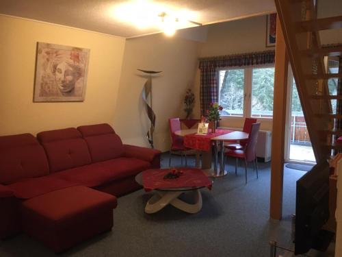 トートモースにあるHaus Dachsberg Todtmoosのリビングルーム(赤いソファ、テーブル付)