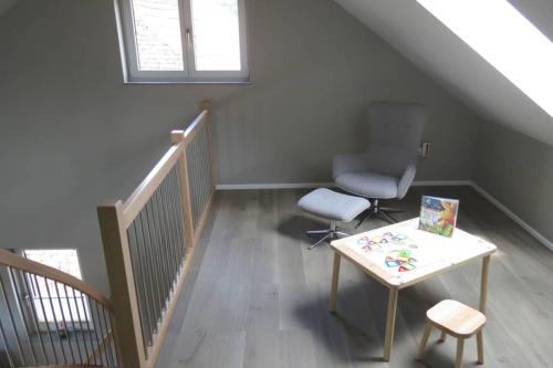 a stair room with a chair and a table at Ferienwohnung 'Burgblick' in Wertheim