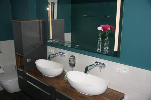 a bathroom with two sinks and a mirror and a toilet at Ferienwohnung 'Burgblick' in Wertheim