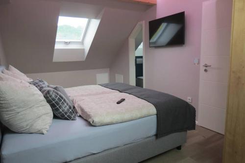 a bedroom with a bed with a television on the wall at Ferienwohnung 'Burgblick' in Wertheim
