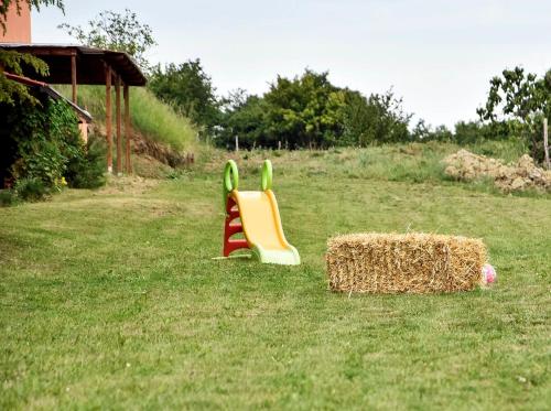 two childrens play equipment in a yard with a stack of hay at Camping Jakomin in Koper
