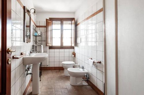 baño con 2 lavabos, aseo y ventana en Antonella House -Podere della Collina, en Palaia