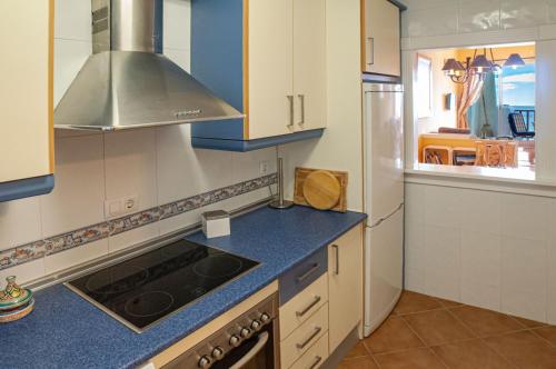 a kitchen with a stove top oven next to a refrigerator at CASA LA ISLETA PLAYA in La Isleta del Moro