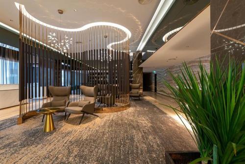 un vestíbulo con sillas y plantas en un edificio en Ames Hotel en Melaka