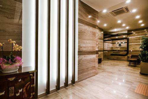 a lobby with wooden walls and a hallway with flowers at Namyangju Benikea JD Hotel in Namyangju