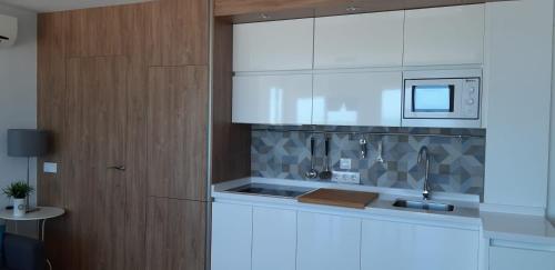 a kitchen with a sink and a microwave at PRIMERA LINEA DE PLAYA EN VALDELAGRANA in El Puerto de Santa María