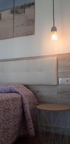 a bedroom with a bed and a table and a picture at PRIMERA LINEA DE PLAYA EN VALDELAGRANA in El Puerto de Santa María