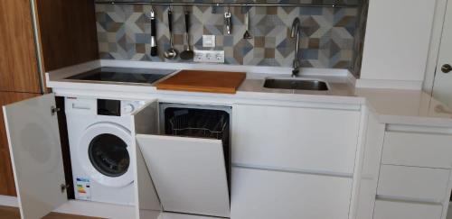 a kitchen with a washing machine and a sink at PRIMERA LINEA DE PLAYA EN VALDELAGRANA in El Puerto de Santa María