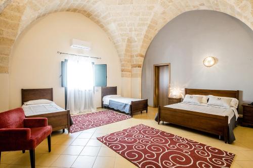 a bedroom with two beds and a chair and a rug at Laurito Resort & Spa in Oria