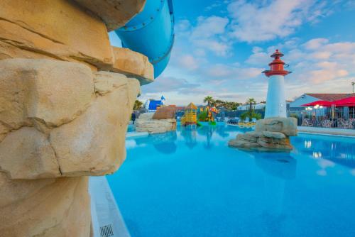 a pool at the resort with a lighthouse at Mobile Homes by KelAir at Camping Sol a Go Go in Saint-Hilaire-de-Riez