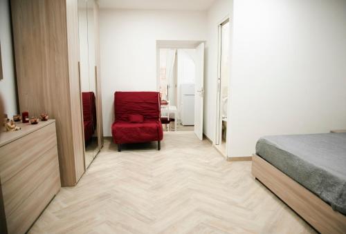- une chambre avec une chaise rouge et un lit dans l'établissement Appartament Peppino Home, à Naples