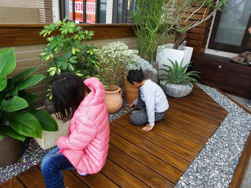 two young children planting plants on a porch at Ciao Home in Toucheng