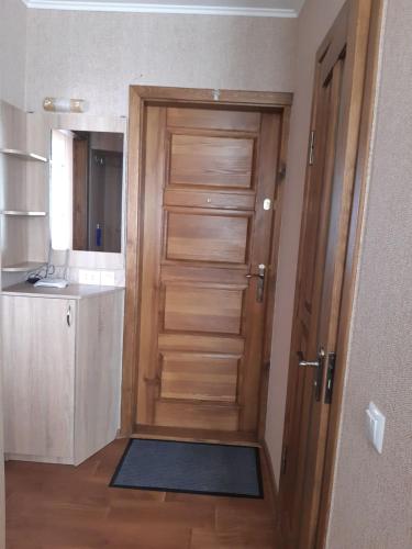 a wooden door in a kitchen with a sink at Однокімнатна in Shepetivka