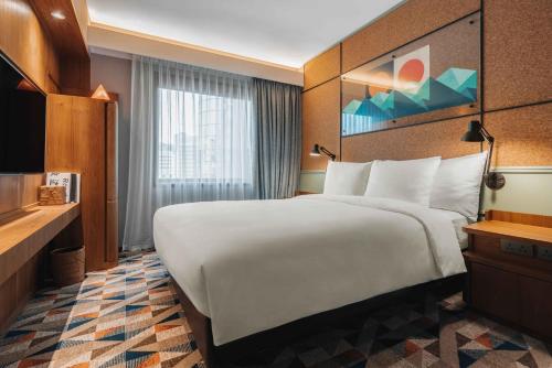 a hotel room with a large bed and a window at Eaton HK in Hong Kong