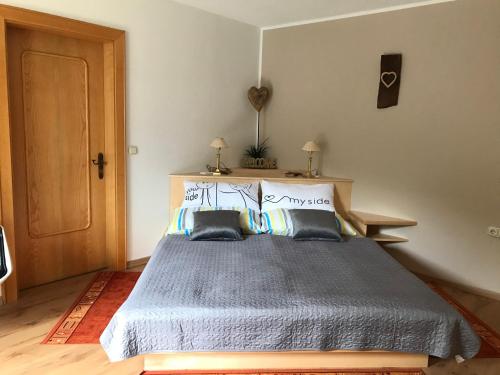 a bedroom with a blue bed with two pillows at Gästehaus Hanser in Virgen