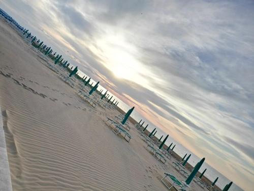 a group of chairs on a beach with the ocean at Albergo 2 Pini in Rodi Garganico