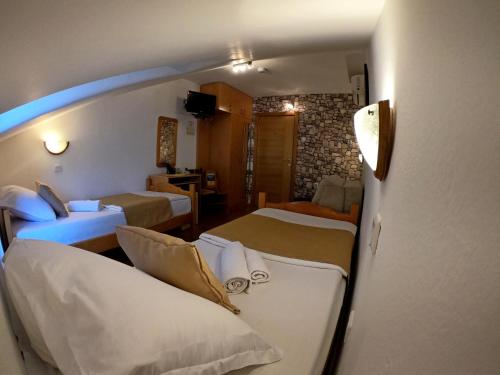 a hotel room with two beds and a couch at Hotel Bokeljski Dvori in Kotor