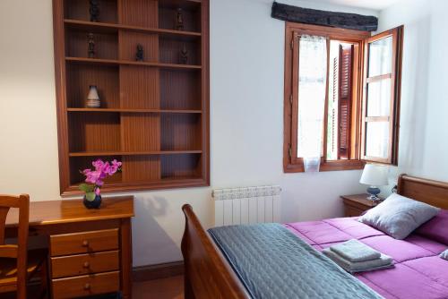 a bedroom with a bed and a desk and a window at Casa Rural Areano in Escoriaza