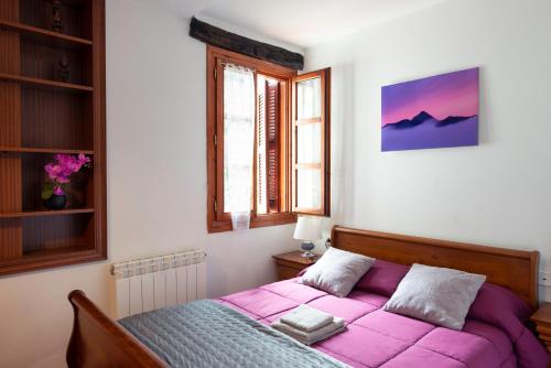 a bedroom with a bed with a pink blanket at Casa Rural Areano in Escoriaza