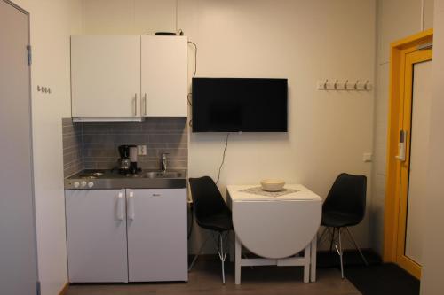 una pequeña cocina con armarios blancos y fregadero en Joker Bø, en Bø i Vesterålen