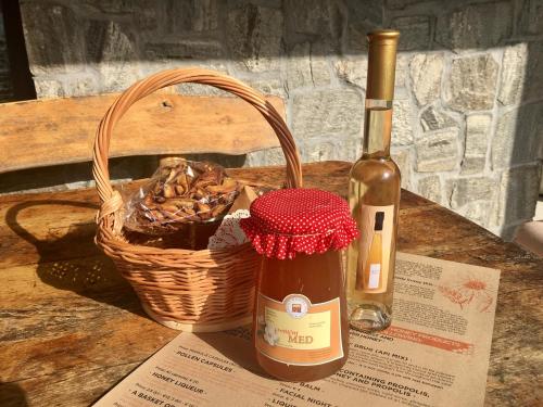 a bottle of wine next to a basket and a bottle of wine at Vineyard Cottage Planinc in Črnomelj