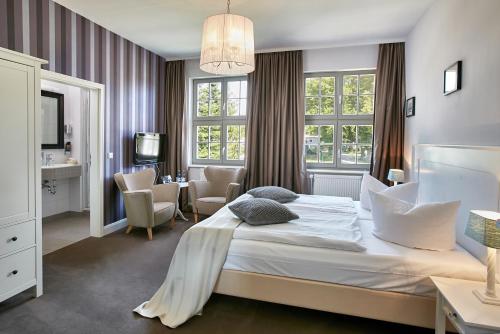 um quarto com uma cama, uma secretária e cadeiras em Gut Vorbeck em Gneven