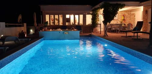 a swimming pool in a yard at night at Villa Lucia with private pool and a whirlpool in Vis