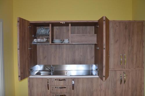 a kitchen with a stainless steel sink and wooden cabinets at I fiori del Pollino - Guest House in San Severino Lucano