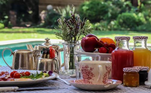een tafel met borden met eten en drinken bij Maison H Guest House in Durban
