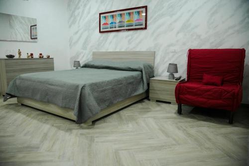- une chambre avec un lit et une chaise rouge dans l'établissement Appartament Home Maria, à Naples