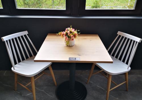 a table with a vase of flowers sitting between two chairs at Hotel Aitana in Irún