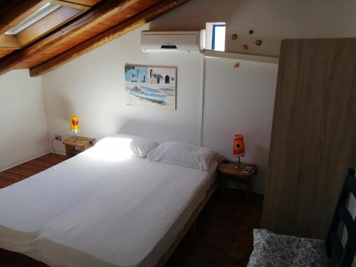 ロッカルメーラにあるCasa Sole Mareのベッドルーム1室(白い大型ベッド1台付)
