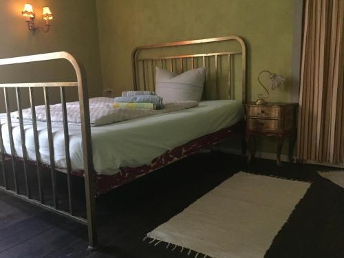 een slaapkamer met een bed met een metalen frame en een tafel bij 1948 es war einmal in Berlijn