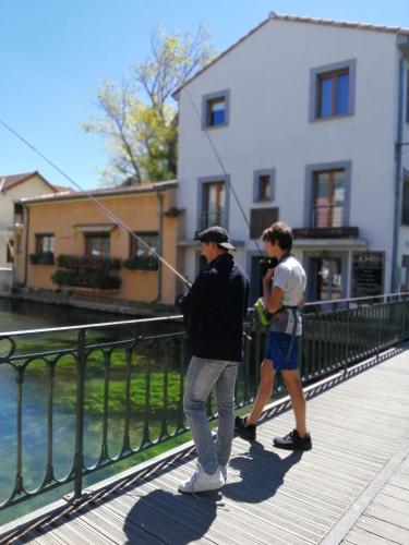 two men standing on a bridge flying a kite at Le Petit Studio - 15 m2 - Centre Ville - Sorgue à 50 m in LʼIsle-sur-la-Sorgue