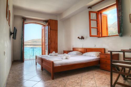 a bedroom with a bed and a large window at Guesthouse Palataki in Neon Oitilon