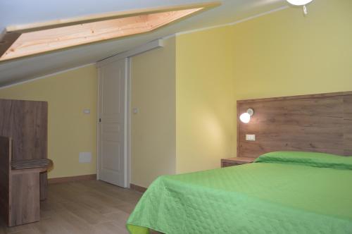 a bedroom with a green bed with a wooden headboard at I fiori del Pollino - Guest House in San Severino Lucano