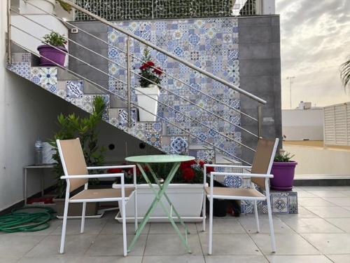 a table and chairs on a balcony with stairs at B&B Palazzo Diaz in Marsala