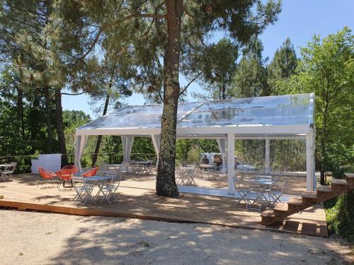 einen weißen Pavillon mit Stühlen, Tischen und einem Baum in der Unterkunft Le Mas de Baume in Rosières