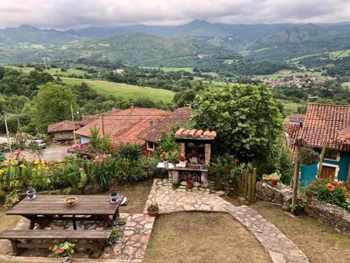 a garden with a picnic table and a view of mountains at La Xica in Beceña