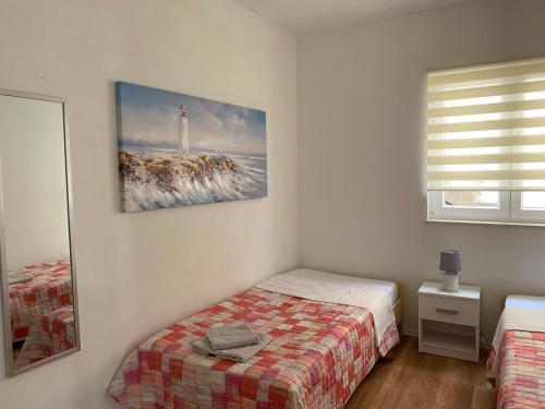 a bedroom with a bed and a picture of a lighthouse at Sunce by the Sea in Blaževo