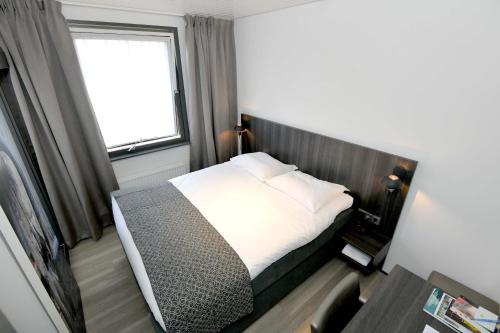 a bedroom with a bed and a window at Het Wapen van Elst in Elst