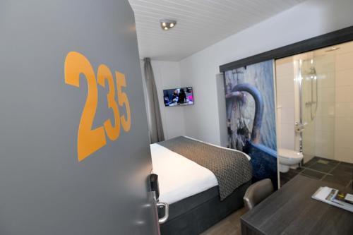 a small room with a bed and a bathroom at Het Wapen van Elst in Elst