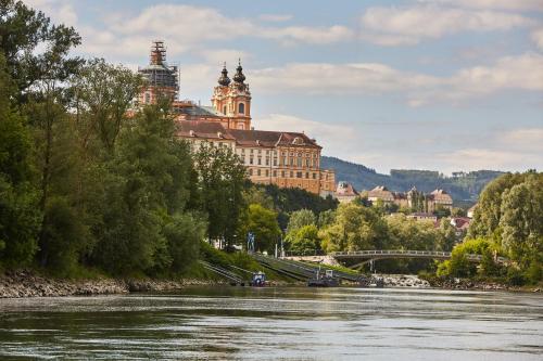 a view of a river with a large building at Hotel Donauhof in Emmersdorf an der Donau