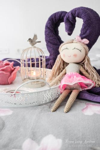 a doll sitting next to a bird cage and a candle at Korona Apartman Székesfehérvár in Székesfehérvár