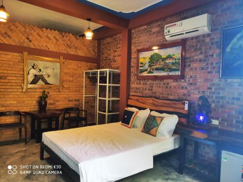 a bedroom with a bed and a brick wall at Vu's Homestay in Phong Nha