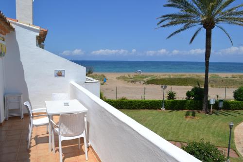 a balcony with a table and chairs and the beach at Playa del Sol - Primera Línea in Denia