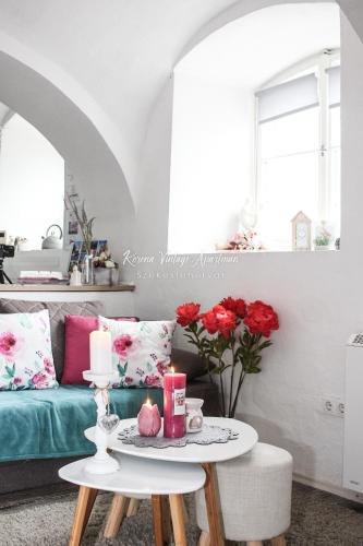 a living room with a couch and a table with candles at Korona Apartman Székesfehérvár in Székesfehérvár