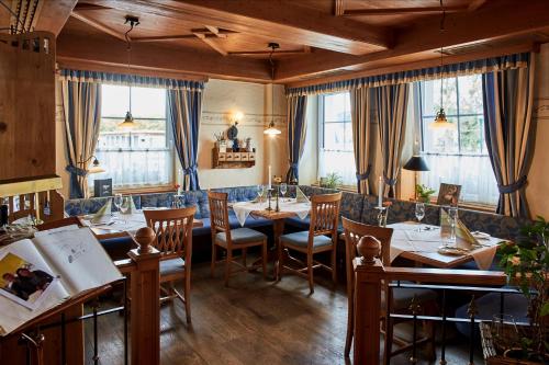 a restaurant with tables and chairs and windows at Hotel Donauhof in Emmersdorf an der Donau