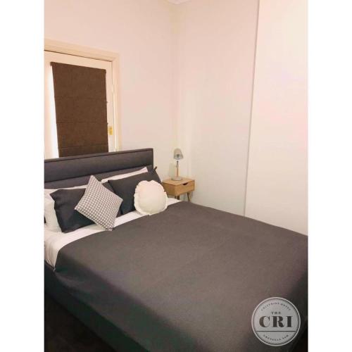 a bedroom with a large bed with black and white pillows at The Cri on Main in Grenfell