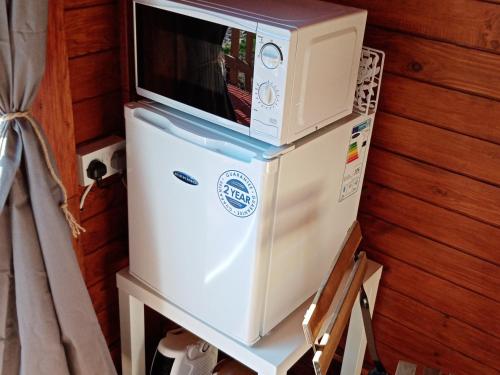 a microwave sitting on top of a refrigerator at Wee Hoose Glamping 3 in Kinbrace